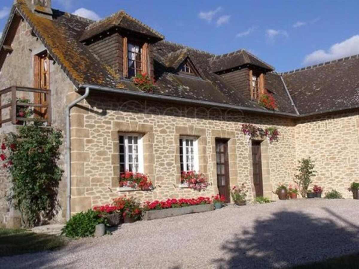 Le Mont Rôti Chambres d’Hôtes - stone farmhouse and flowering courtyard in Normandy